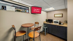 A small office space with a desk, two chairs, a printer, and a sign indicating free Wi-Fi in all rooms. - Red Roof Inn Dallas - DFW Airport North (Irving)