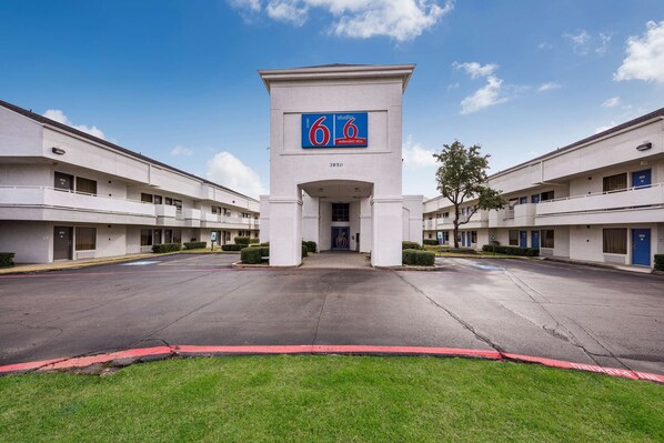 A modern hotel with a central entrance, numbered 3950, and a sign indicating extended stay availability.