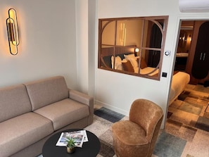 A modern living room with a sofa, armchair, and a coffee table.