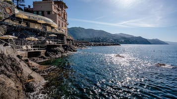 A coastal building with a restaurant named "EXCELSIOR" on the upper level, overlooking the sea.
