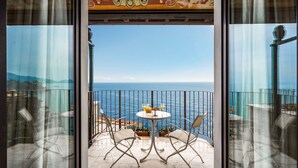 Un balcón con mesa y sillas, con vista al mar.