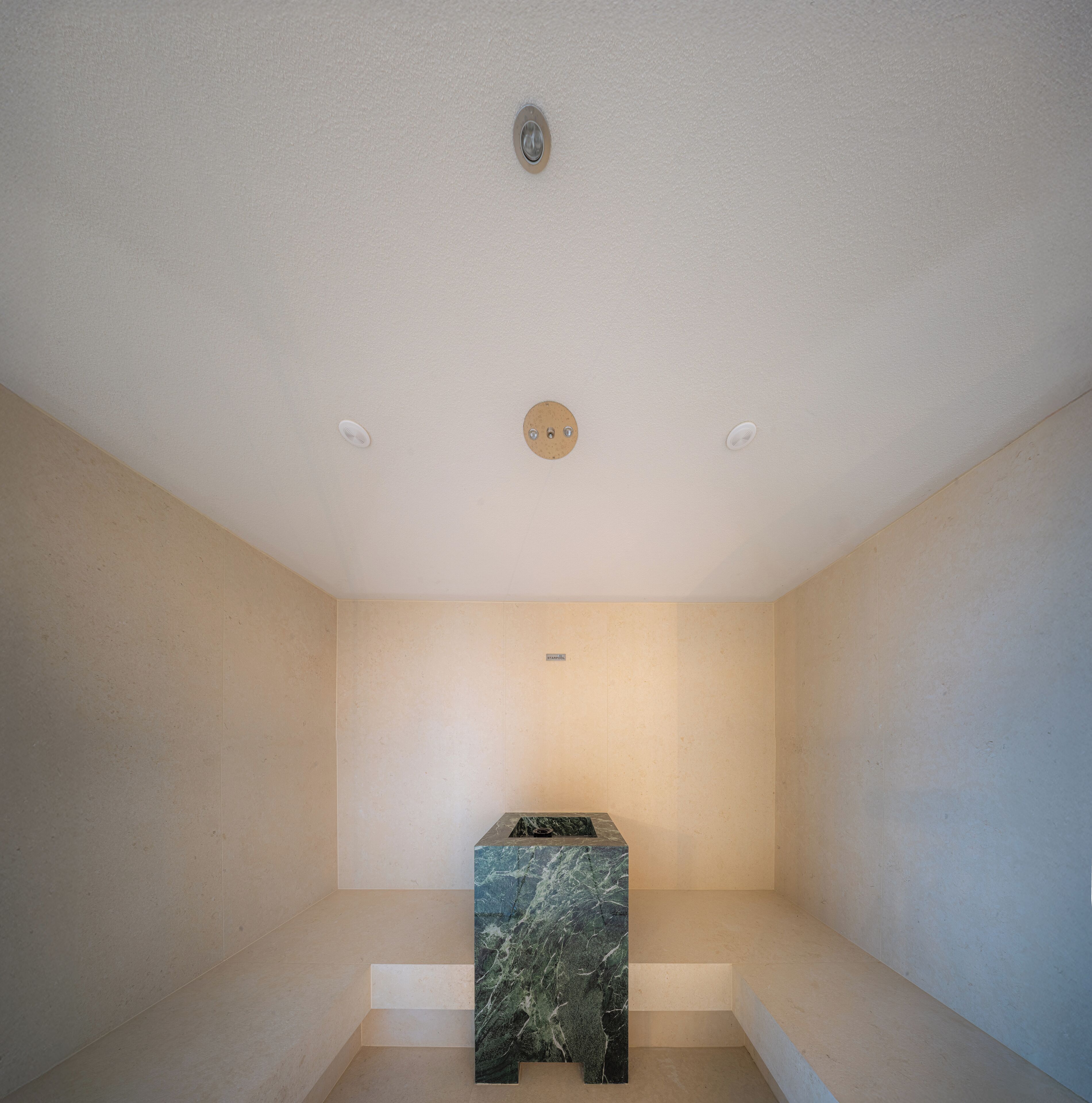 A minimalist bathroom with a marble sink and recessed ceiling lights.