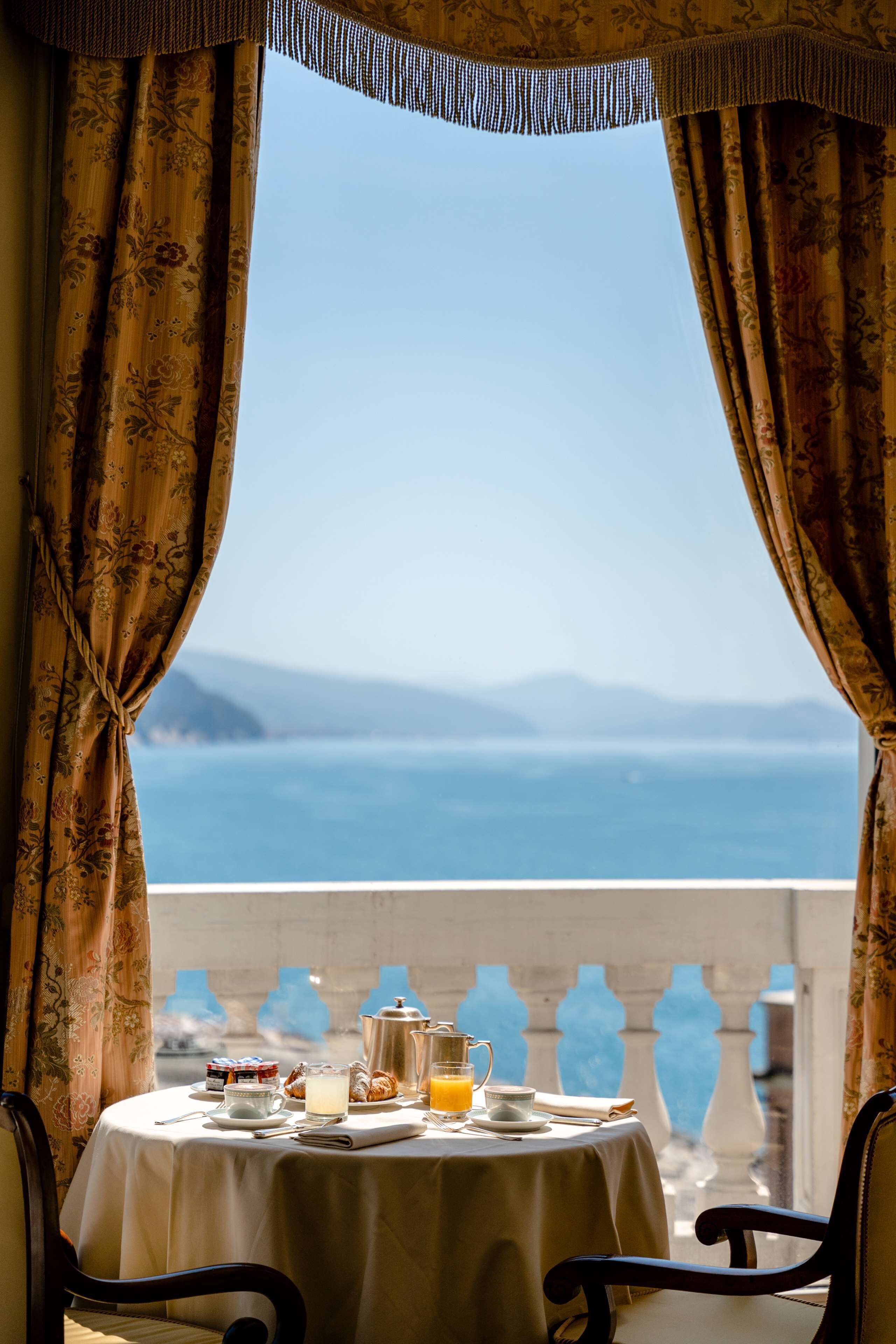 A table set for breakfast with a view of the sea.