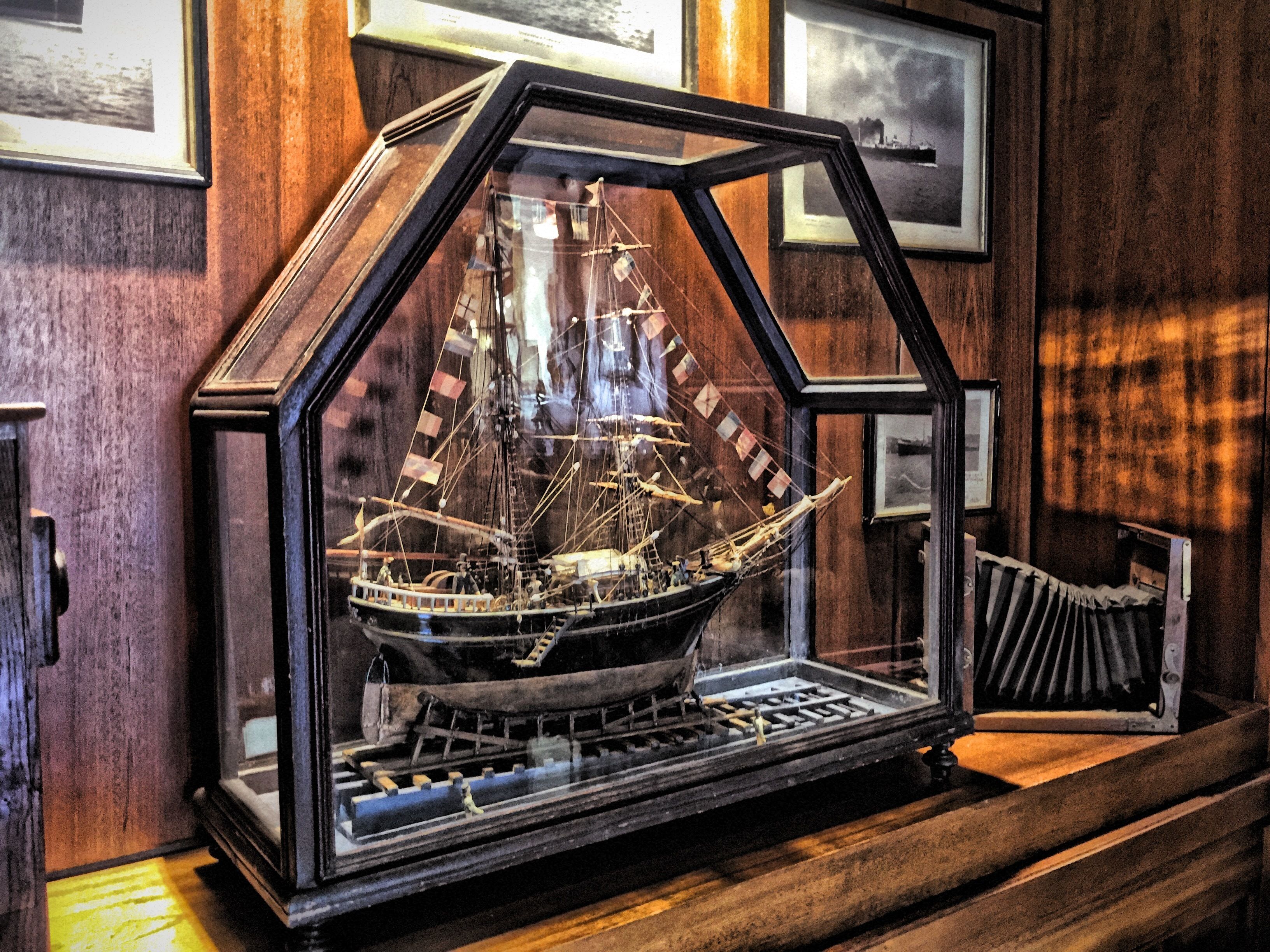 A model ship in a hexagonal display case.