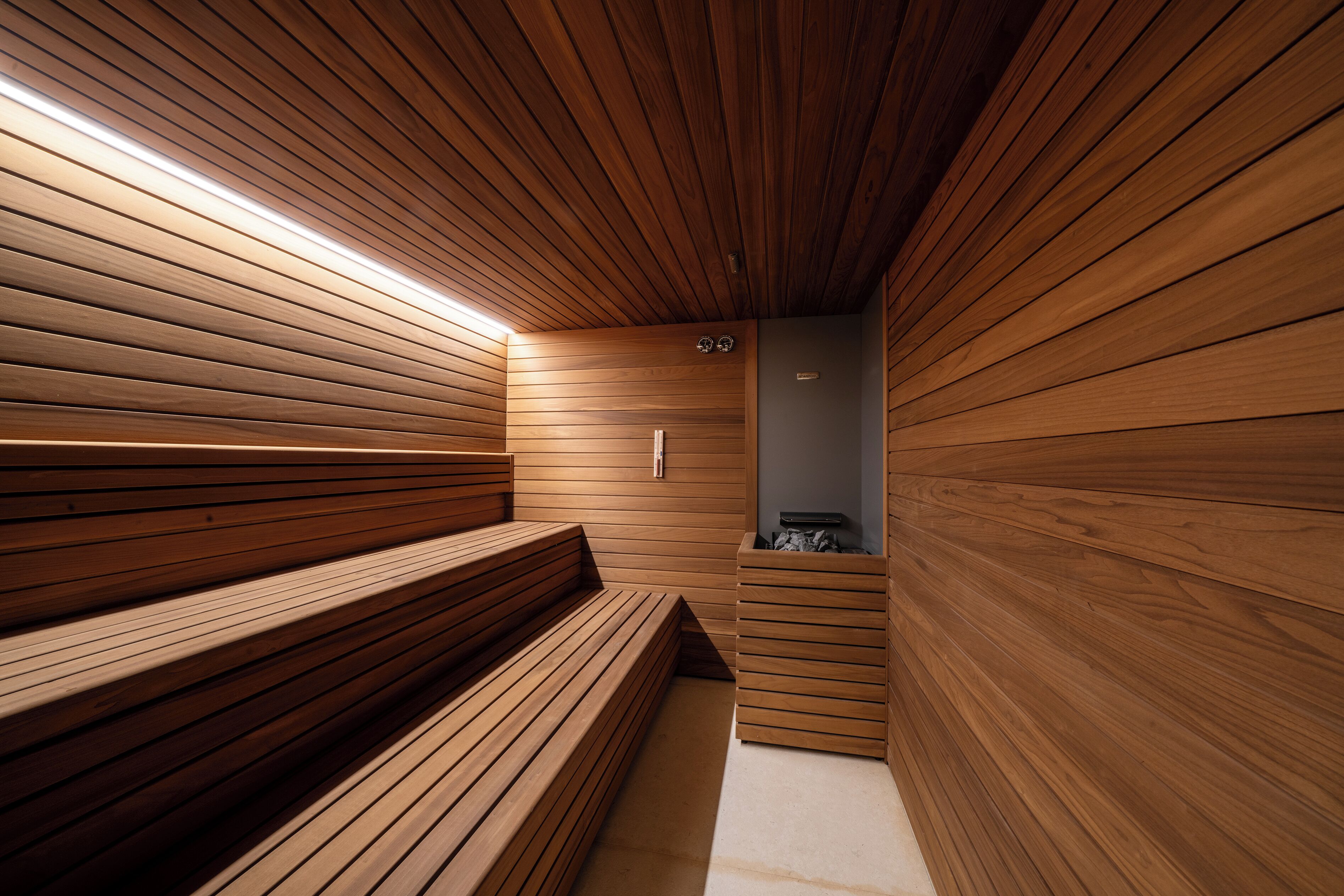Un sauna avec des bancs en bois et un banc au centre.