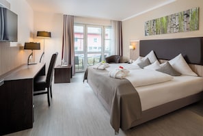 A hotel room with a bed, a desk, a chair, a TV, and a window with curtains. - Best Western Plus Parkhotel Erding (Erding)