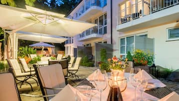 An outdoor dining area with tables, chairs, and umbrellas.