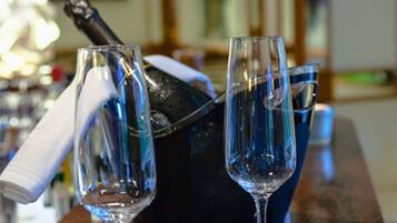 Una zona de bar con dos copas de champán sobre una bandeja, una botella de champán y un cubo azul.