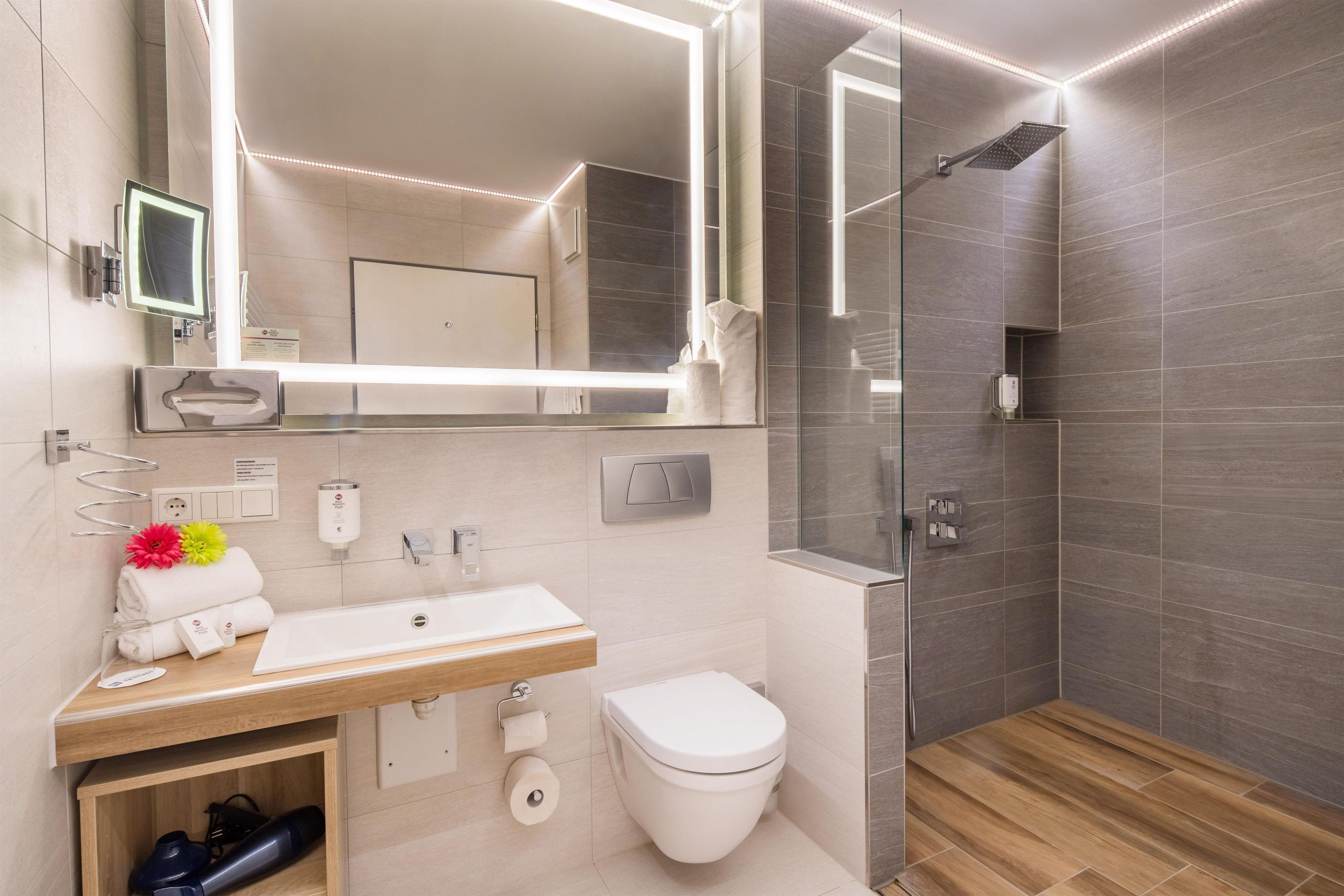 Une salle de bain moderne avec un meuble-lavabo, des toilettes et un espace douche.