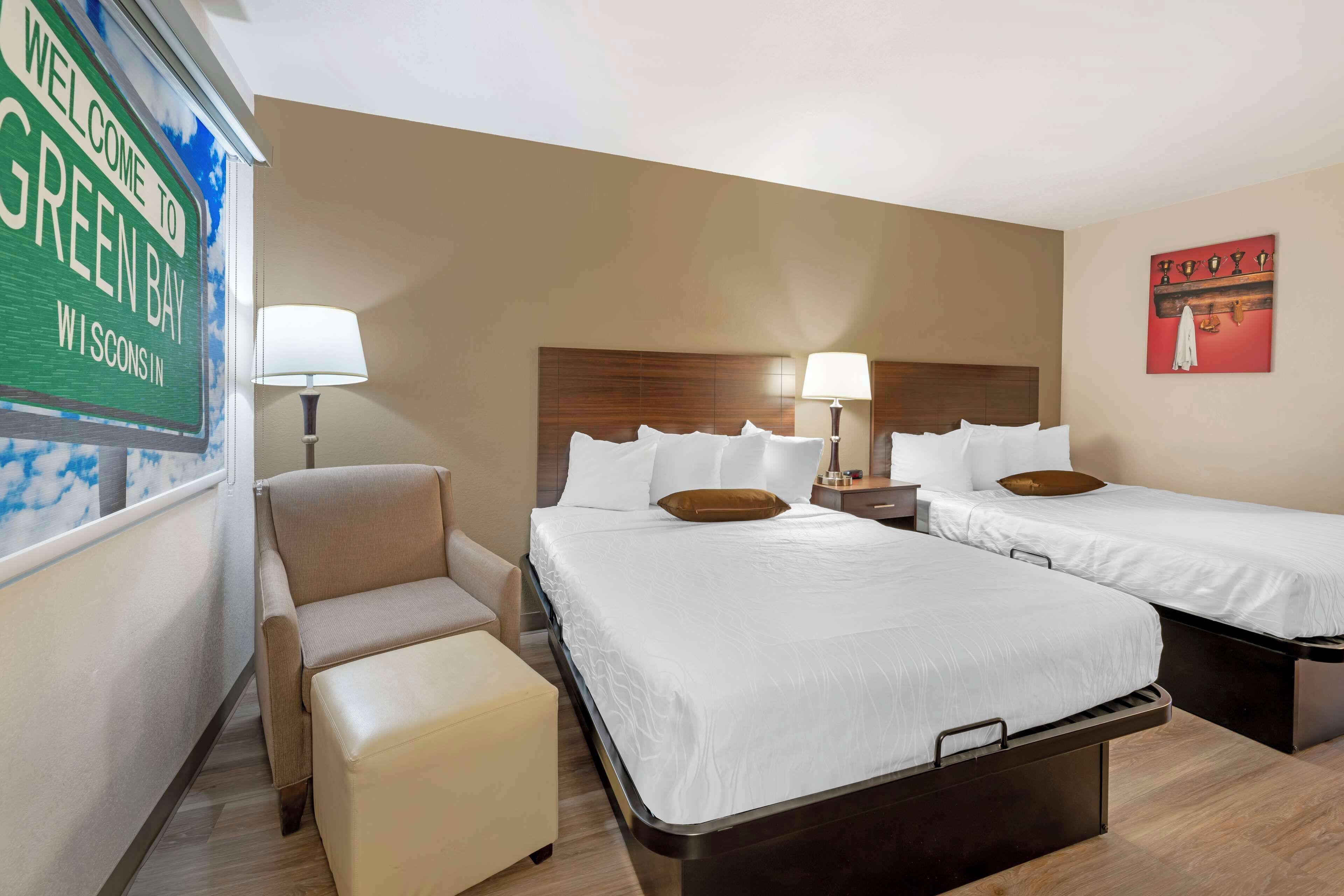 Ein Hotelzimmer mit zwei Betten, einem Sofa und einem kleinen Tisch.