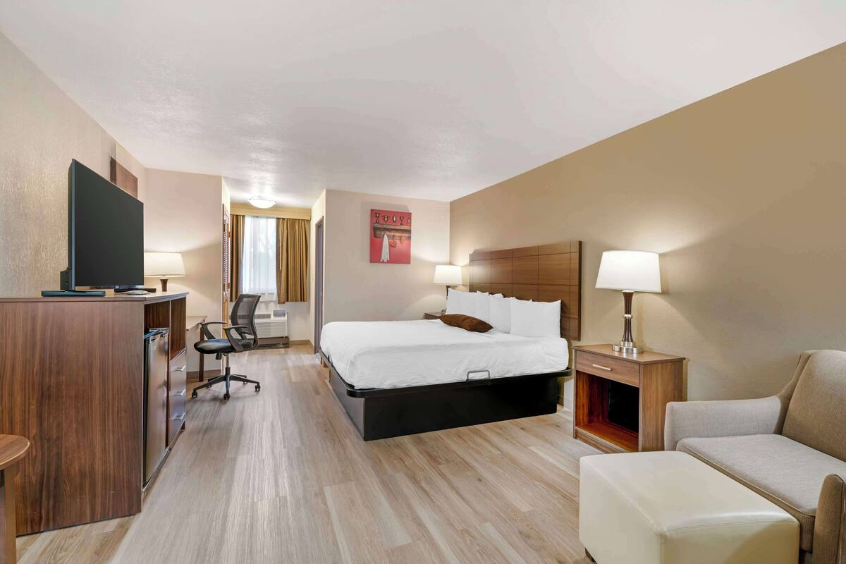 Une chambre d’hôtel équipée d’un lit, d’un bureau, d’une chaise et d’un téléviseur.