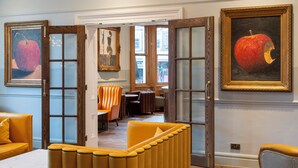 A room with a yellow sofa, a table, and a painting of an apple. - The Queen at Chester Hotel - Handwritten Collection (Chester)