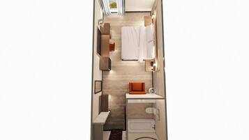 A compact hotel room with a bed, a small seating area, a desk, and a bathroom.