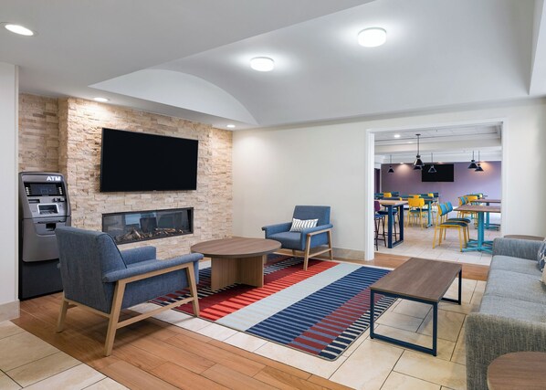 Una sala de estar moderna con chimenea, asientos y televisor.