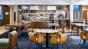 Un restaurante moderno con zona de bar, mesas y un tablero de menú.