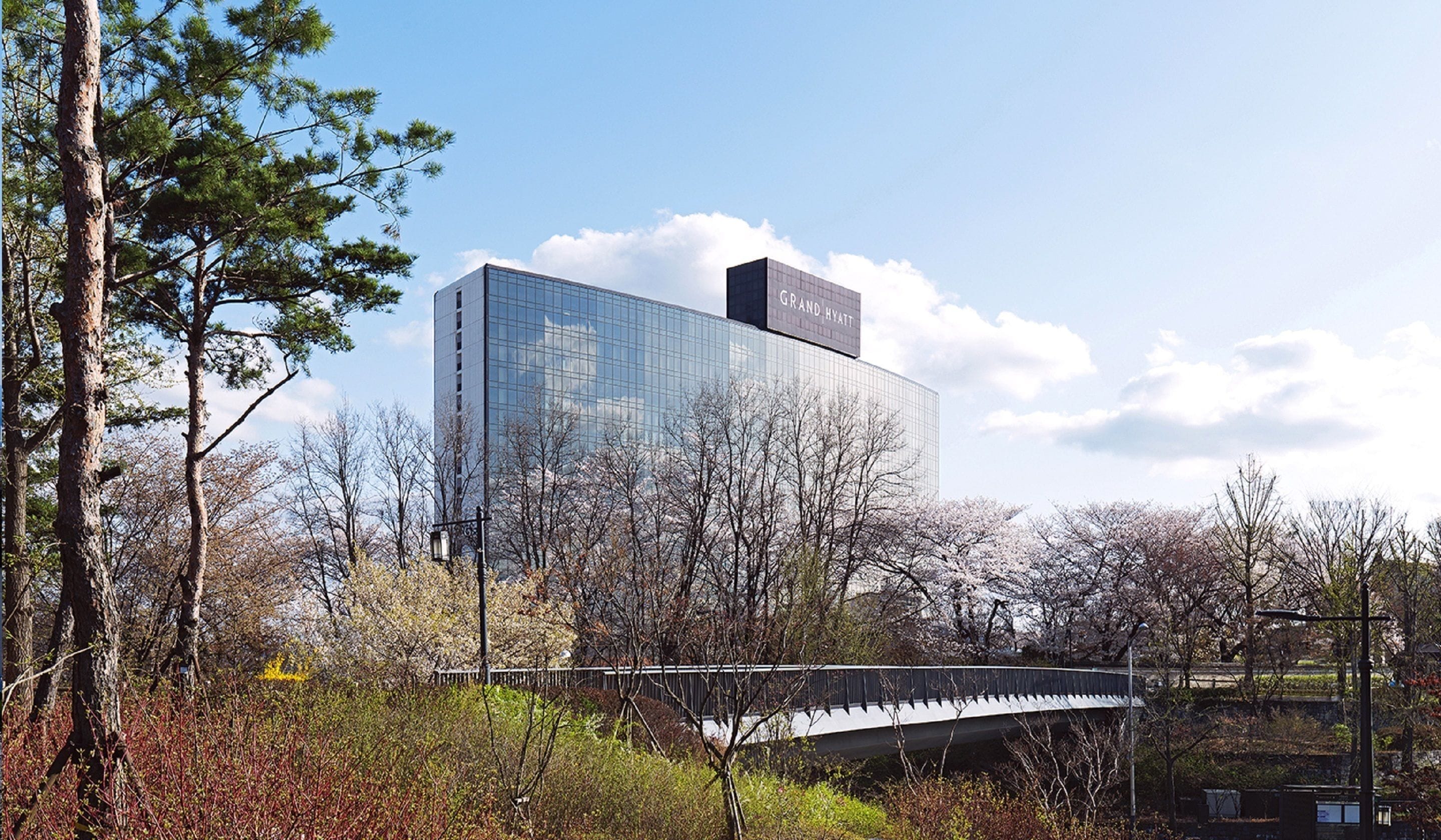 Un hotel moderno con fachada de vidrio y un letrero que dice "Grand Hyatt".