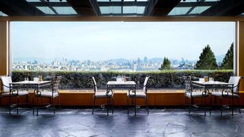 A restaurant with a large window overlooking a cityscape.