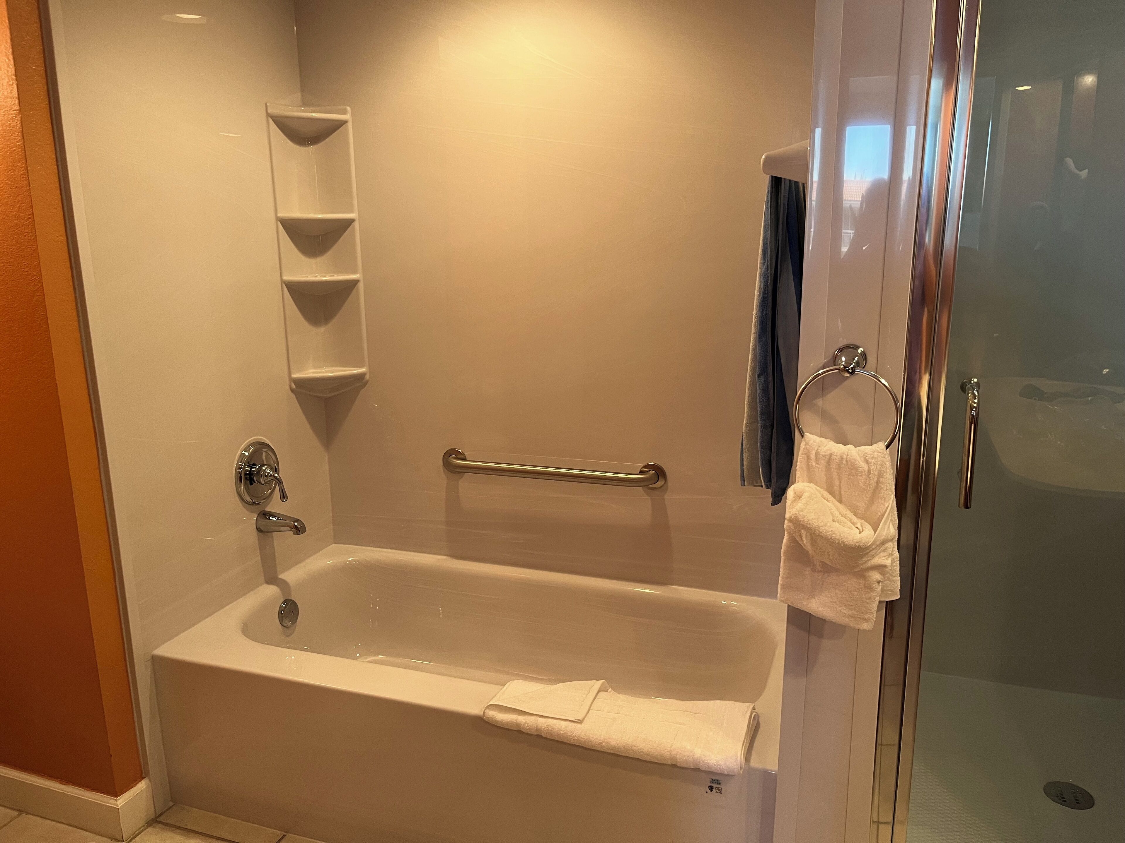 A modern bathroom with a bathtub, a shower, and a glass-enclosed shower area.