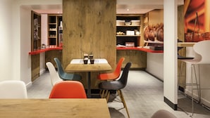 Un comedor moderno con una mesa de madera, sillas coloridas y una encimera con cestas y utensilios de cocina.