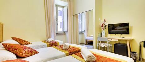 A hotel room with two beds, a desk with a TV, a chair, and a small table.