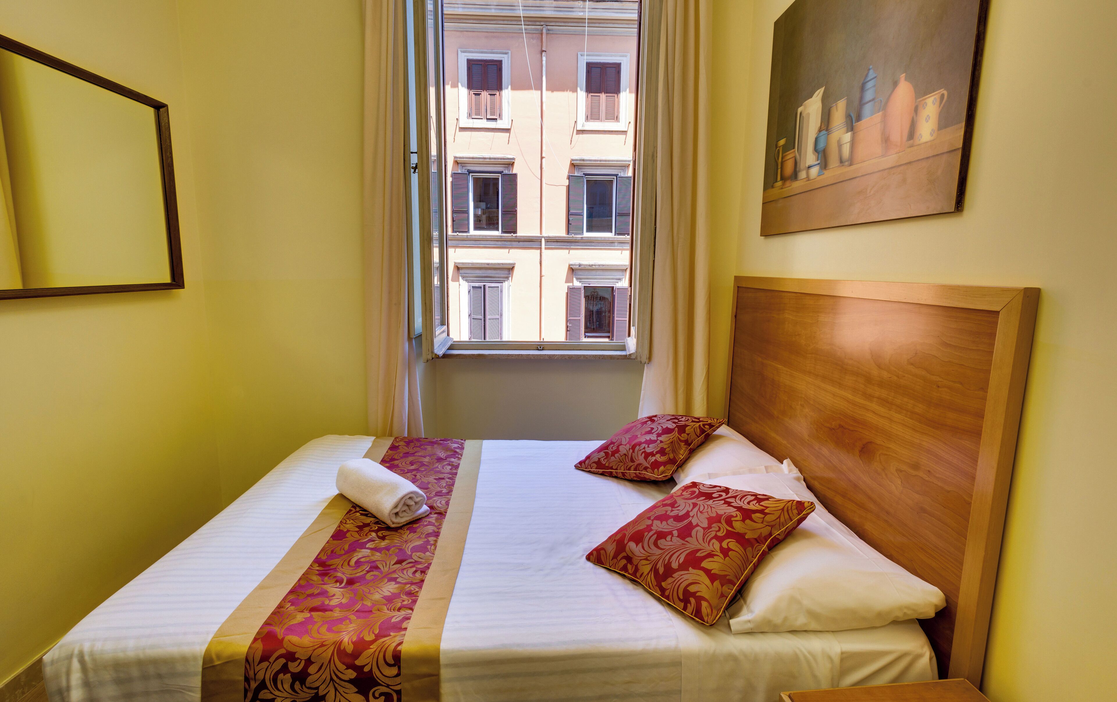 Una habitación de hotel con una cama, un ventanal y un cuadro en la pared.