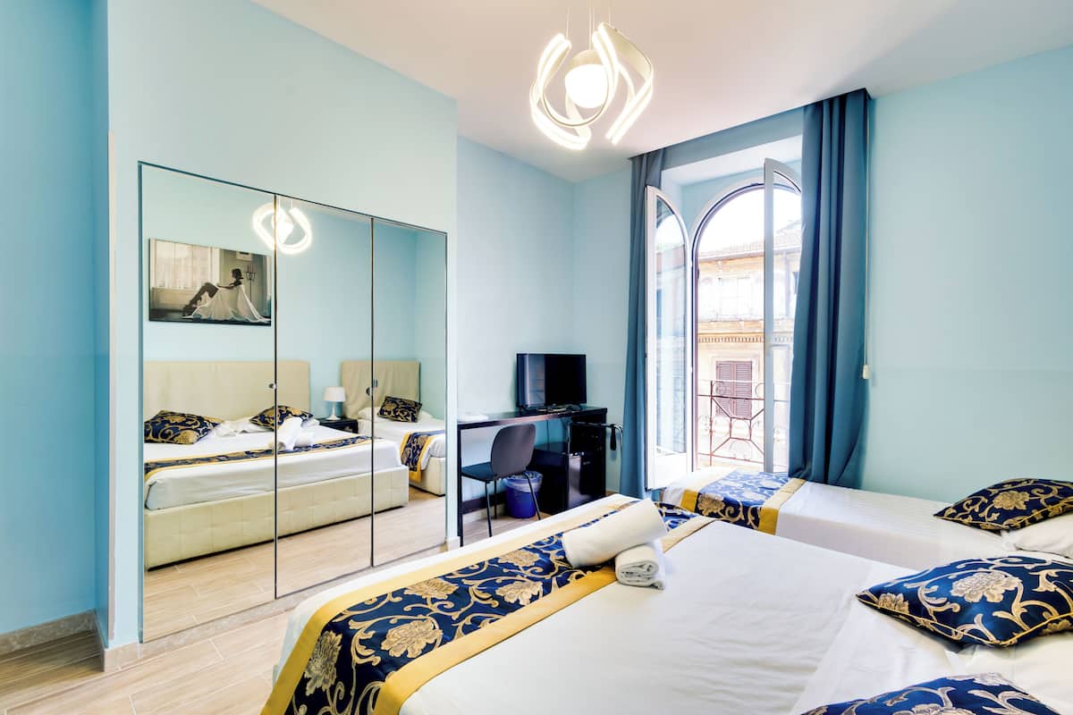 Une chambre d’hôtel avec un grand lit, un bureau, une télévision et un miroir.