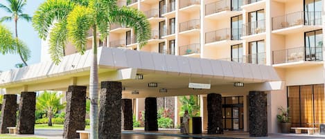 A hotel entrance with a covered walkway, stone pillars, and a clear sign indicating a clearance of 11'-6".