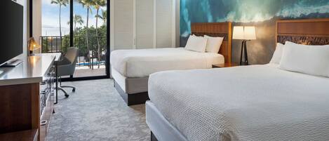 A hotel room with two beds, a desk, a chair, a TV, and a view of palm trees and the ocean.
