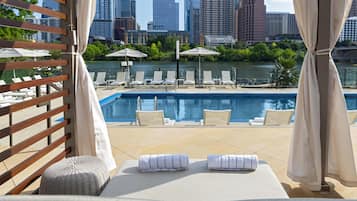 Een buitenzwembad, zwembadcabana's (toeslag) en parasols bij het zwembad