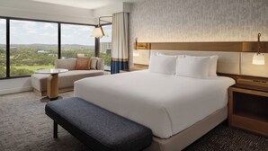 A hotel room with a large bed, a sofa, a small table, and a bench. - Hyatt Regency Austin (Austin)
