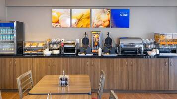 A breakfast bar with various food items and a coffee station.