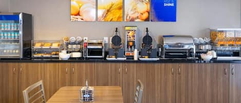 Una barra de desayuno con diversas opciones de comida y una estación de café.