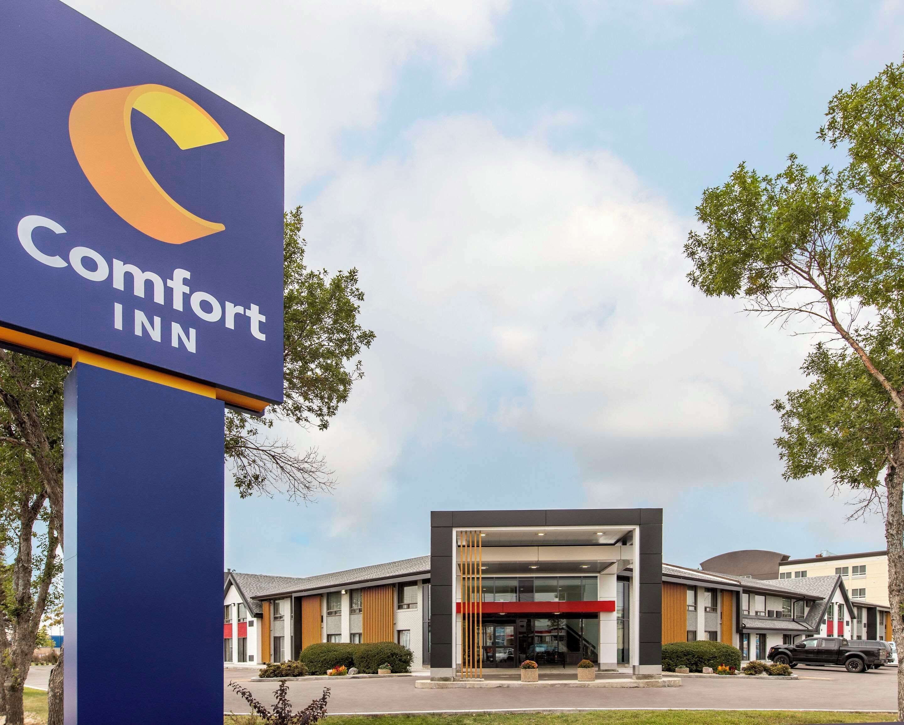 L’entrée d’un hôtel Comfort Inn, dotée d’un design moderne, avec une enseigne bien visible et un espace d’entrée abrité.