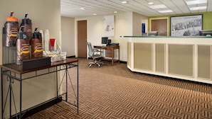 A reception area with a reception desk, a computer, and a coffee station with decaf and hot water dispensers. - Super 8 by Wyndham Chambersburg I-81 (Chambersburg)
