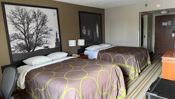 A hotel room with two beds, a desk, a chair, and a dresser.