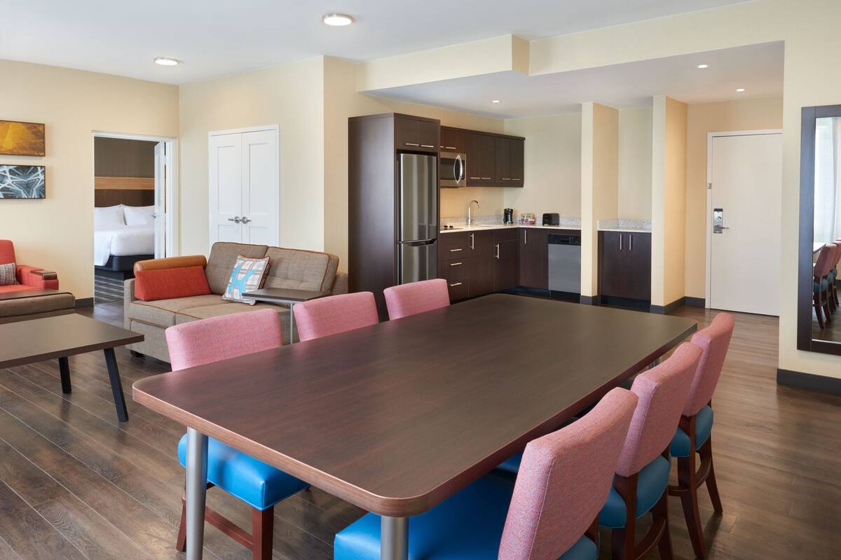 A modern kitchen with dark wooden cabinets, a stainless steel refrigerator, and a built-in microwave.