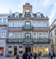 A historic building with multiple floors, large windows, and decorative iron railings.
