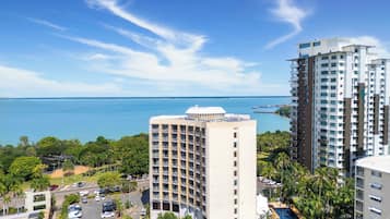 A high-rise hotel with a pool and a view of the ocean.