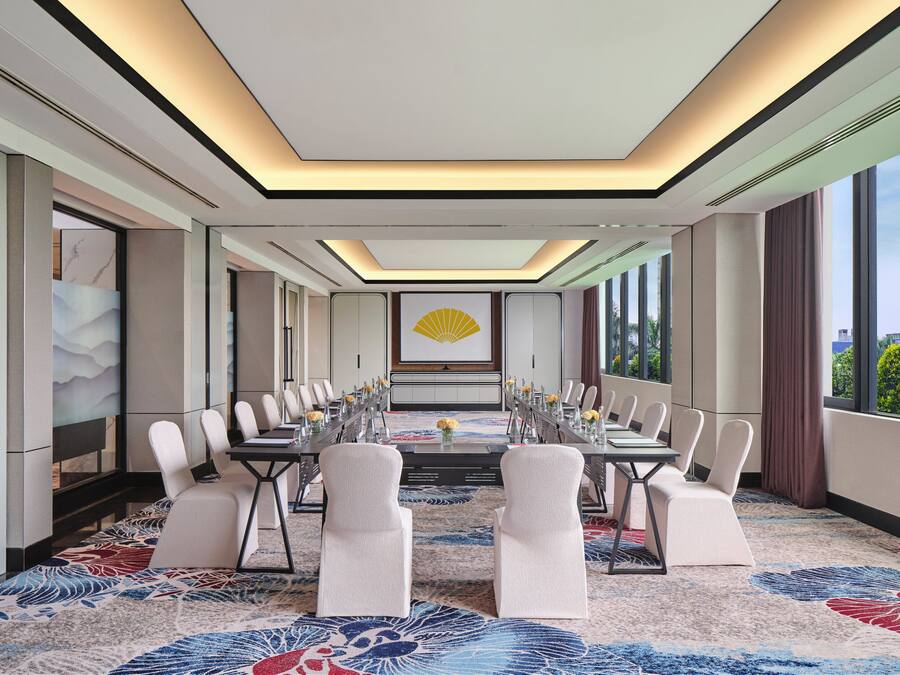 A conference room with a long table, chairs, and a decorative wall piece.