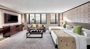 A hotel room with a large TV, a sofa, a bed, and a city view through the windows. - Mandarin Oriental, Jakarta (Jakarta)