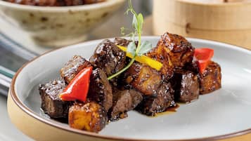 Diverse gerechten op een tafel, waaronder een bord met vlees en groenten, een kom soep, en een bord met dumplings.