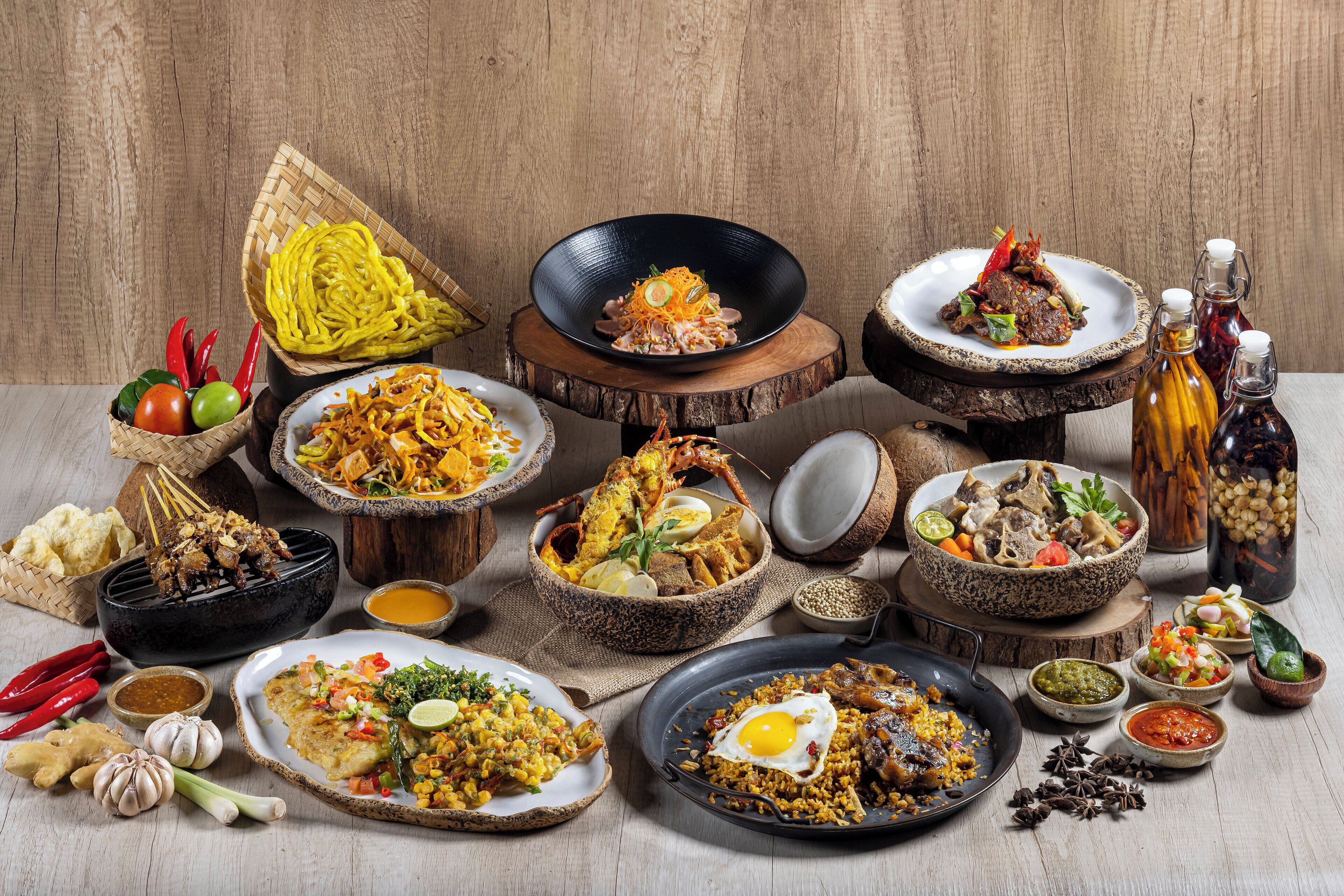 A variety of dishes and condiments arranged on a wooden table.