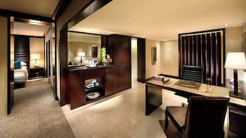 A hotel room with a bed, a desk, a chair, a mirror, a dresser, and a bathroom.