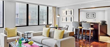 A modern living room with a sofa, coffee table, and dining area.