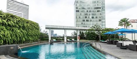 Una piscina al aire libre, sillones reclinables de piscina