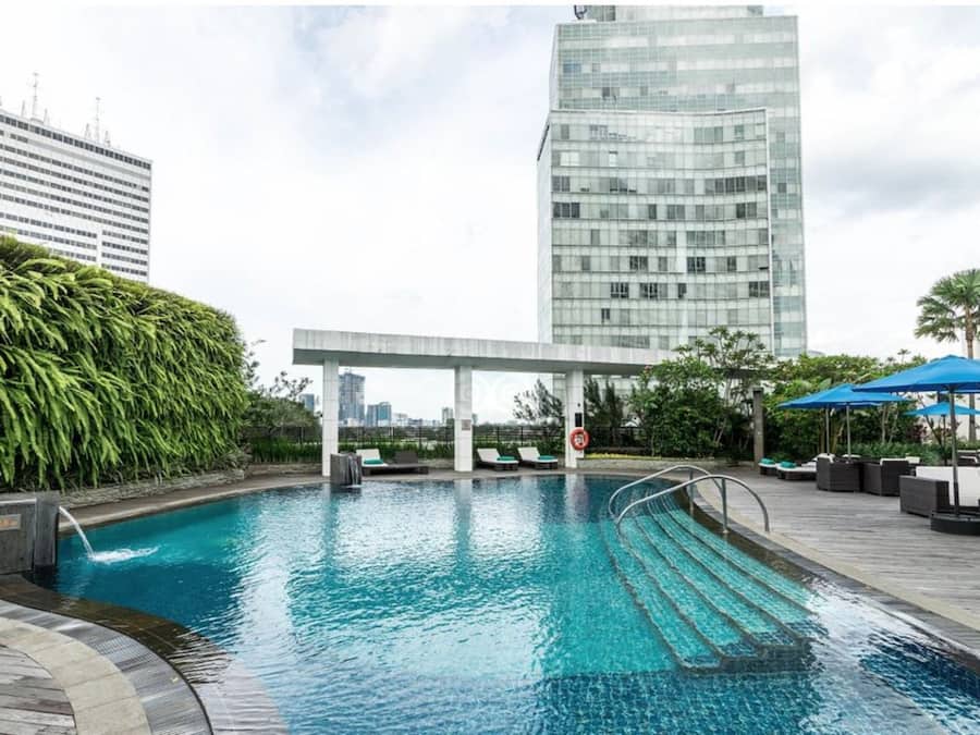 Una piscina al aire libre, sillones reclinables de piscina