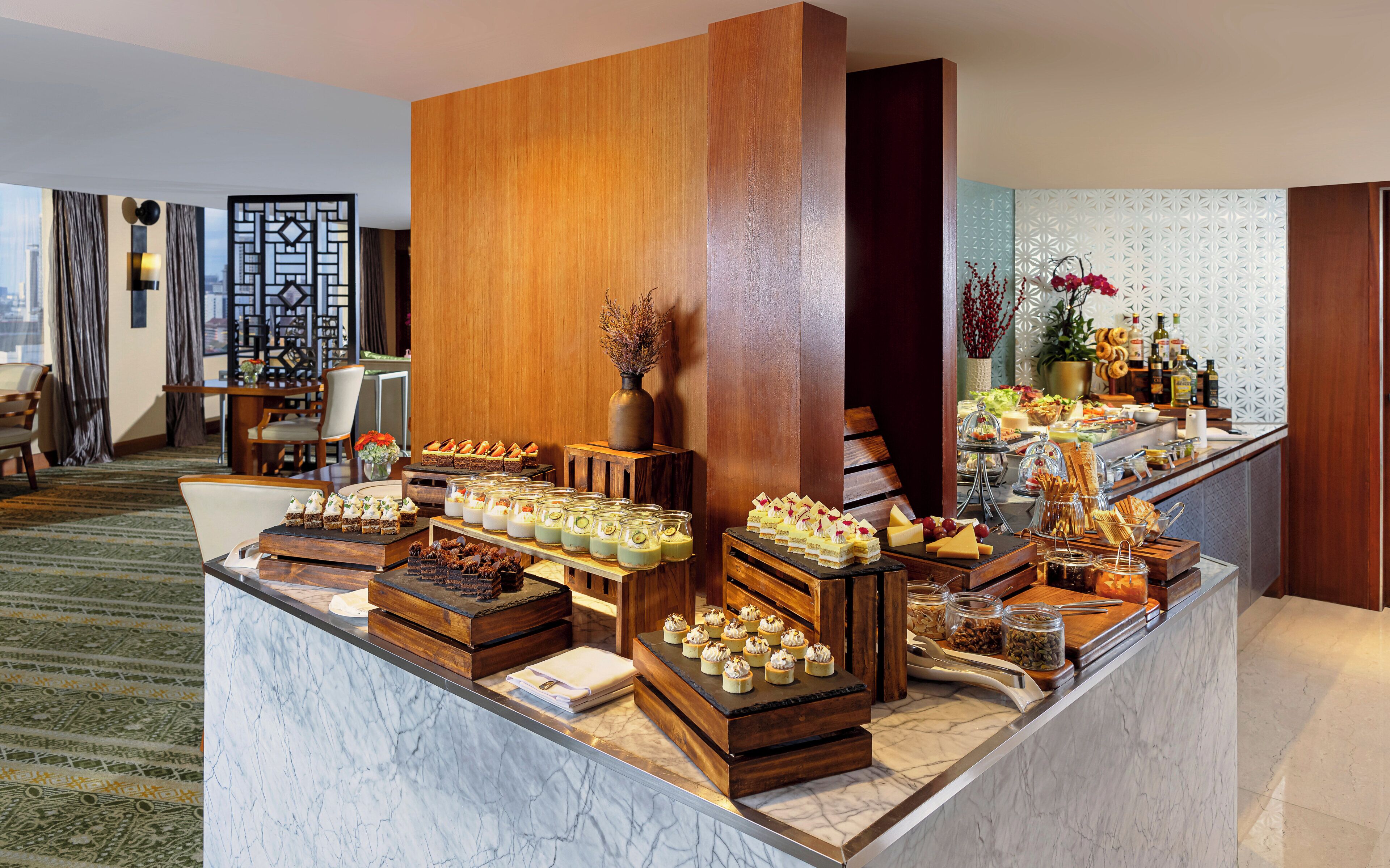 A buffet setup with various food items and a decorative vase.
