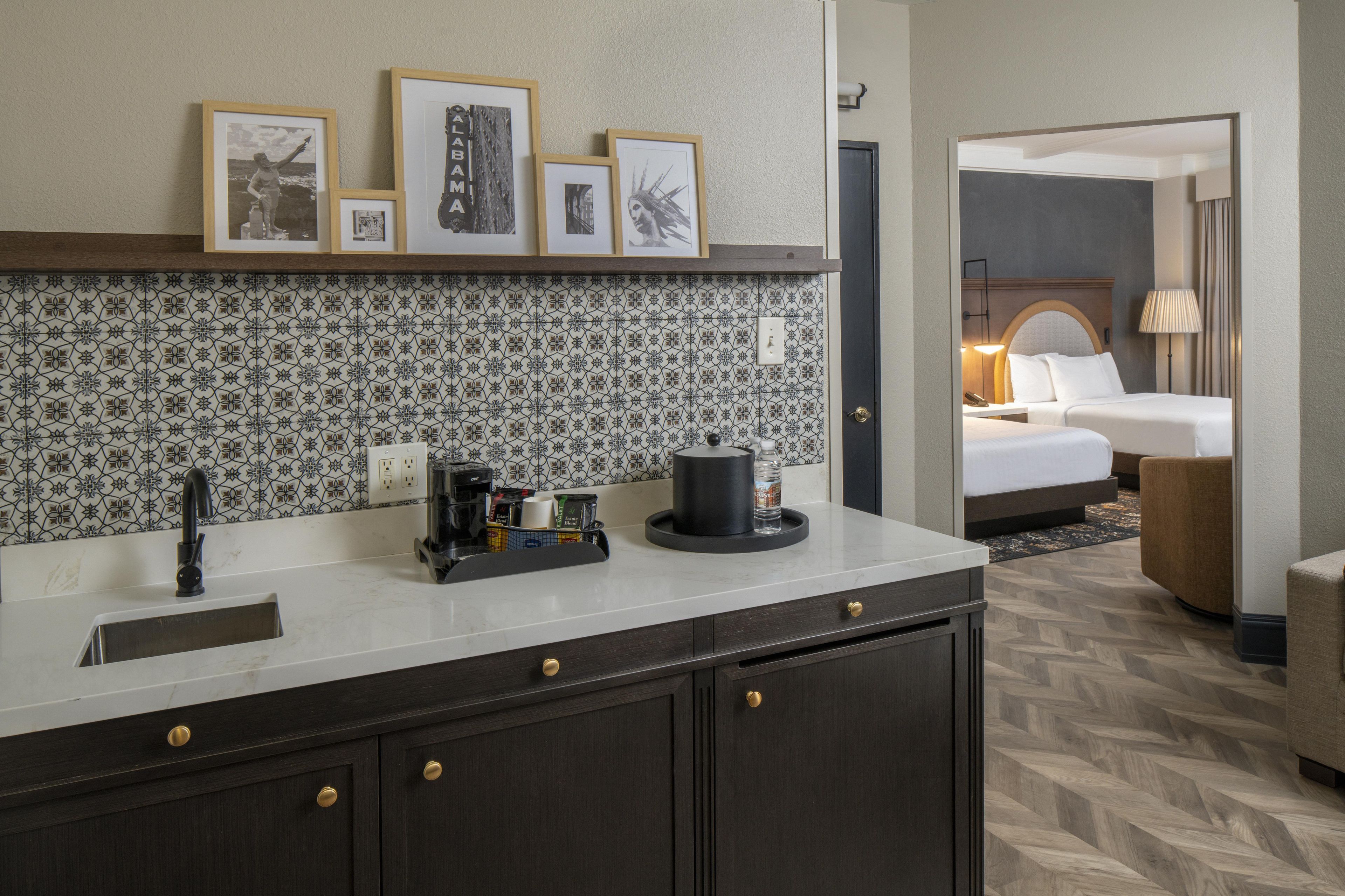 Une chambre d’hôtel équipée d’une kitchenette, d’un lit, d’un coin salon et d’une salle de bain.