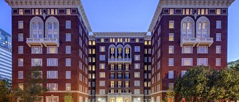 A large, symmetrical building with multiple floors, featuring a central entrance with a grand archway and a series of windows on each floor.
