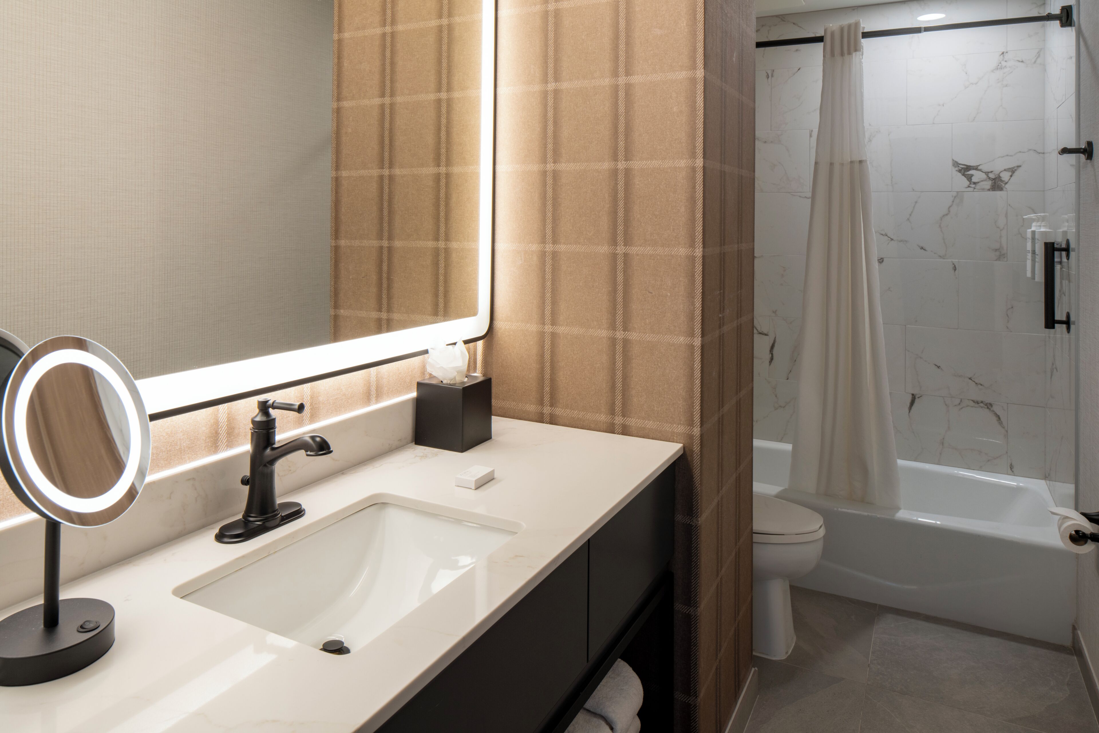 Une salle de bain équipée d’un lavabo, d’un miroir, de toilettes et d’une douche.